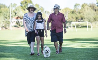 Grandparents and granddaughter with dog at the park